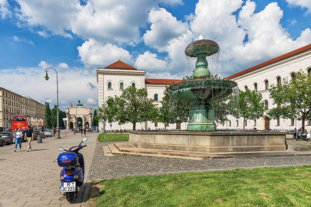 Munich, Germany June 09, 2018: Fountain at Geschwister-Scholl-Platz in Munich. Tourists at the Ludwig Maximilian University of Munich. The university is among the oldest universities of Germany.